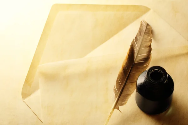 Envelope with inkwell and feather — Stock Photo, Image