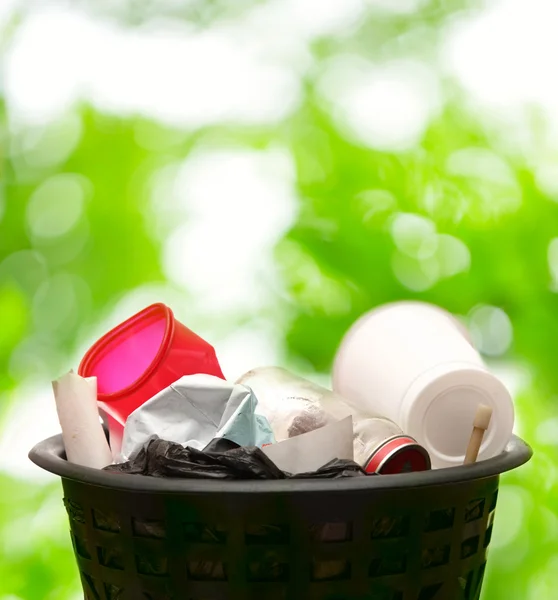 Wastebasket on green leaves — Stock Photo, Image
