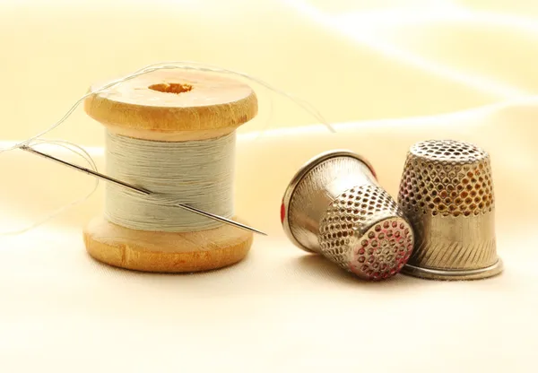 Швейные наперстки, бобин и игла — стоковое фото