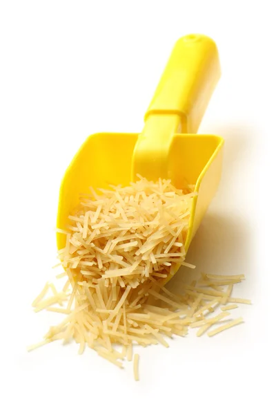 Short pasta in yellow spoon — Stock Photo, Image
