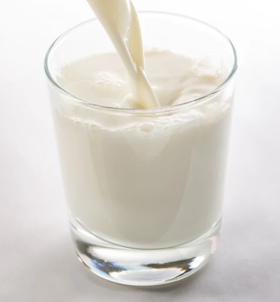 Melk in glas gieten — Stockfoto