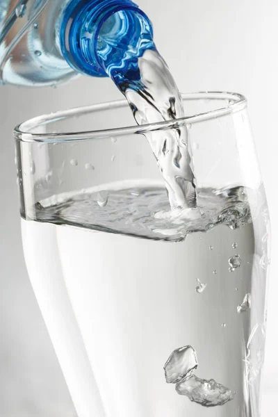 Wasser aus der Flasche gießen — Stockfoto