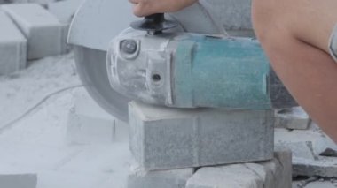 Açı öğütücüyle kaldırım taşı kesen işçiler