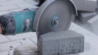 Açı öğütücüyle kaldırım taşı kesen işçiler