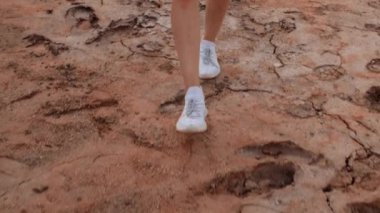 Kurumuş alanda yürüyen bir kadın.