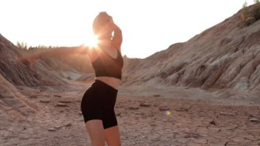 Kurumuş bölgede dans eden bir kadın.