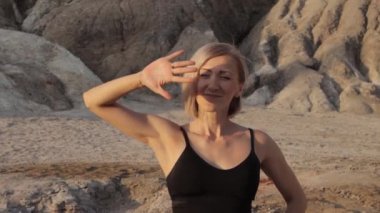 Çölde güneşe bakan sportif kadın.