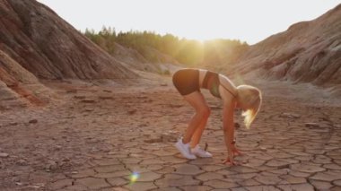 Çölün ortasında spor yapan bir kadın.