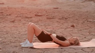 Çölün ortasında spor yapan bir kadın.