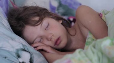 Küçük kız sabah ışığında uyuyor.