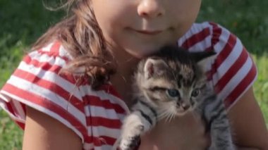 Elinde kedi yavrusu olan küçük kız.