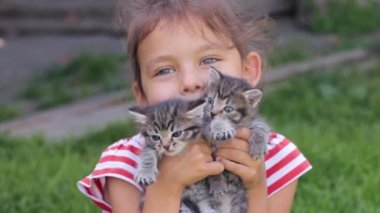 Ellerinde kedi yavruları olan küçük kız