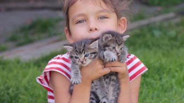 Ellerinde kedi yavruları olan küçük kız