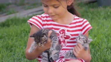 Ellerinde kedi yavruları olan küçük kız