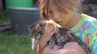 Ellerinde kedi yavruları olan küçük kız