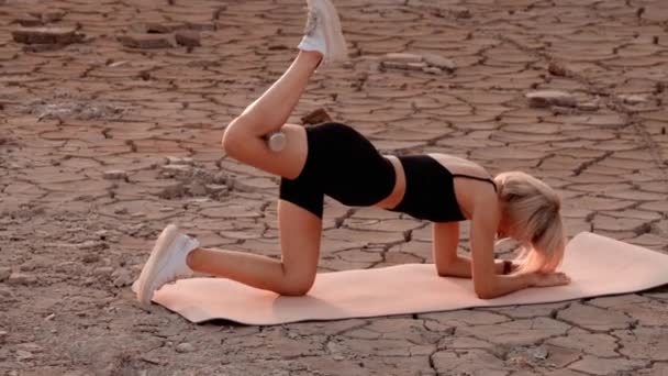 Sportieve vrouw oefenen op woestijn locatie — Stockvideo