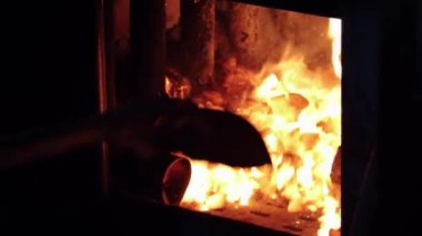 Fırına kürekle kömür atan bir adam.