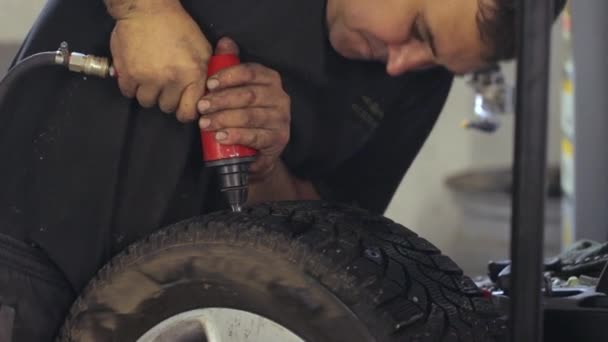 A man replacing old worn-out tire spikes — Stockvideo