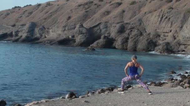 Une femme faisant de l'exercice sur la côte — Video