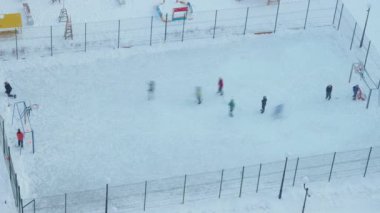 Çocuklar buz pateni sahasında hokey oynuyor