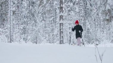 Ormanda derin karlar içinde yürüyen bir kadın.