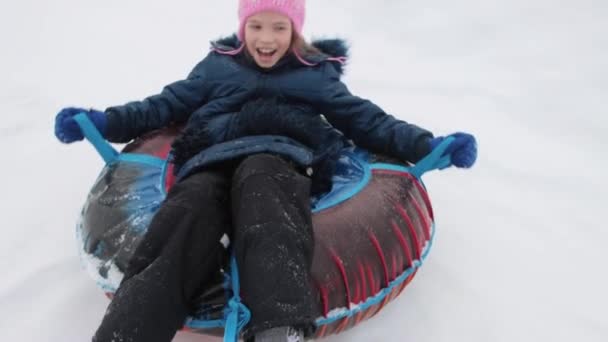 A cheerful happy girl on snow tube — Stock Video