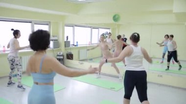 Bir grup kadın koridorda antrenman yapıyor.
