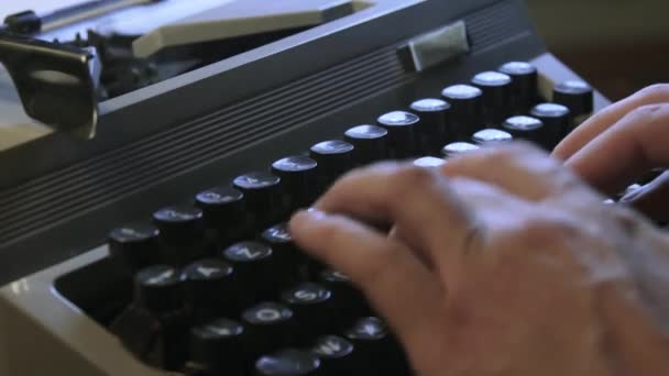Un hombre escribiendo en una máquina de escribir — Vídeo de stock