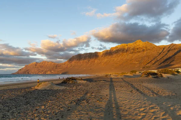 Famara plajı ve Risco de Famara dağları gün batımında İspanya