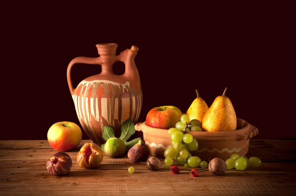 Керамический кувшин и фрукты — стоковое фото