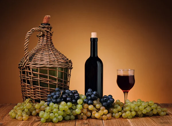 Globo de mimbre tejido vino y uvas — Foto de Stock