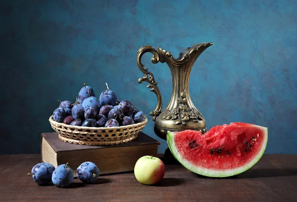 Watermelon slices and plums in wickerbasket — Stock Photo, Image