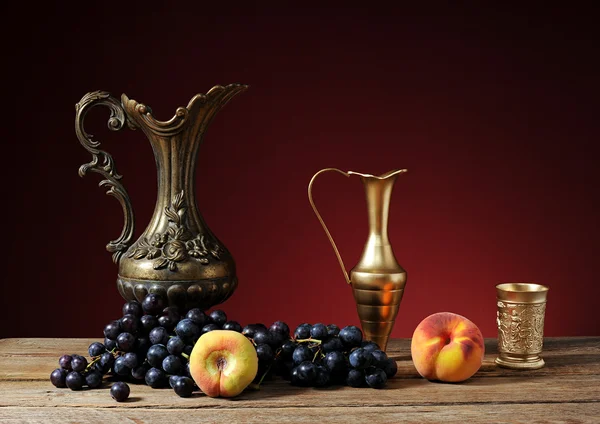 Metal pitcher and fruit — Stock Photo, Image