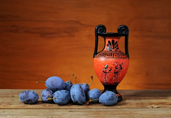 Fresh plums and amphorae — Stock Photo, Image