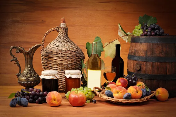 Frutas, compotas e garrafas de vinho — Fotografia de Stock