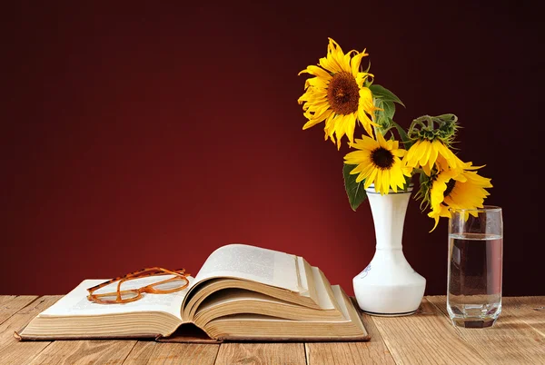 Böcker och solrosor i en vas — Stockfoto