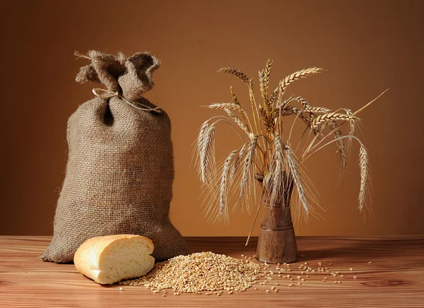 Wheat ears of corn in a vase, and bread — Stock Photo, Image