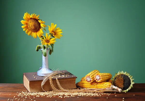 Sonnenblumen in einer Keramikvase und Mais — Stockfoto