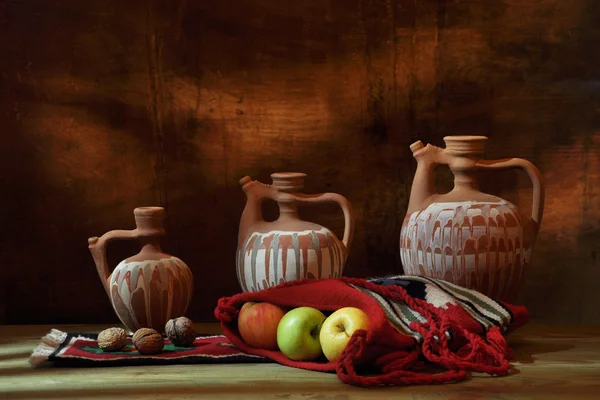 Äpplen i etniska väskor och keramiska skålar — Stockfoto