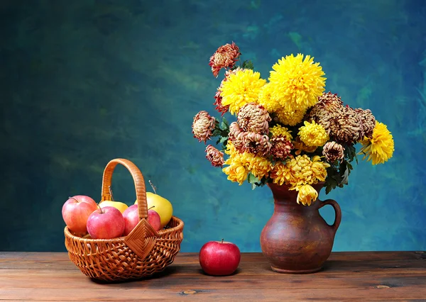 Blumen in einer Keramikvase und Äpfel — Stockfoto