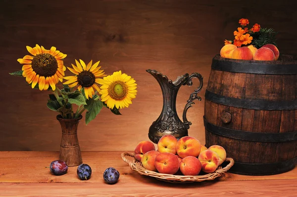 Sonnenblumen in einer Keramikvase und Obst — Stockfoto