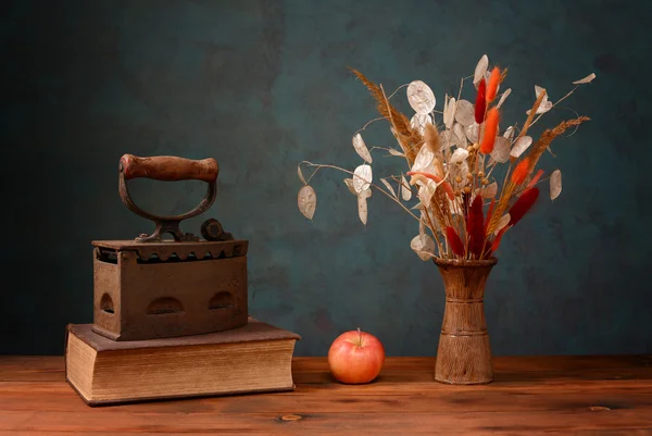 Fleurs séchées dans un vase et livres — Photo