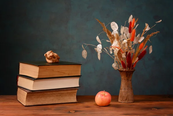 Сушеные цветы в вазе и книгах — стоковое фото