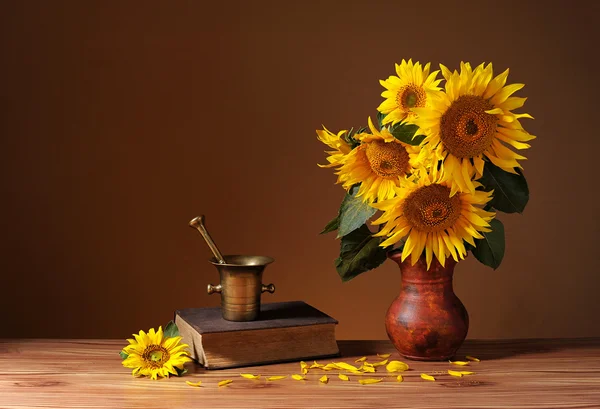 Girasoles en un jarrón de cerámica y libros —  Fotos de Stock