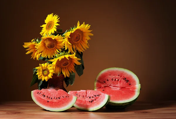 Sunflowers in a vase and watermelon — Stock Photo, Image