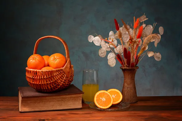 Oranges in wicker baskets and flowers — Stock Photo, Image