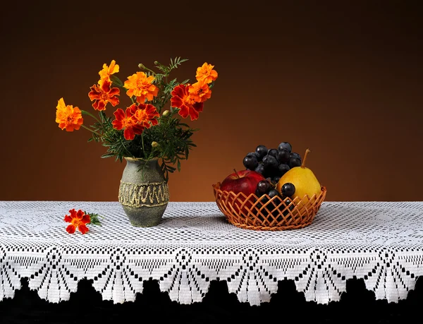 Fleurs dans un vase en céramique et fruits — Photo