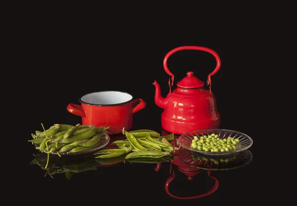 Red metal utensils and peas — Stock Photo, Image