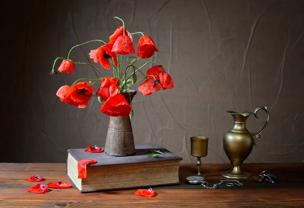 Poppy in ceramic vases, books and metal carafe — Stock Photo, Image