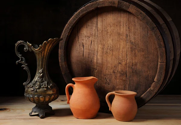 Деревянная бочка, металлический кувшин и глиняная посуда — стоковое фото